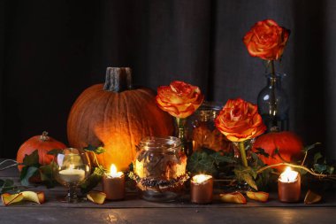 Autumn wedding decoration with pumpkins, orange roses and candle