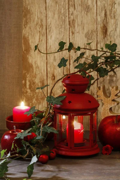 Decoración de Navidad con linterna roja, vela, manzanas y hiedra le — Foto de Stock