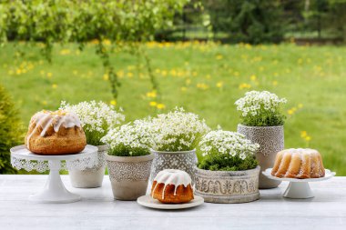 Geleneksel Paskalya pastaları, güzel bahar çiçekleri ve yosun ve bıldırcın yumurtasından yapılmış el yapımı süslemeler..