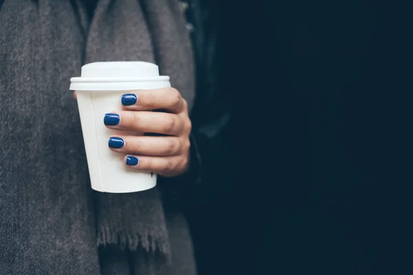 Jovem está bebendo café na rua enquanto caminha no frio dia de inverno — Fotografia de Stock