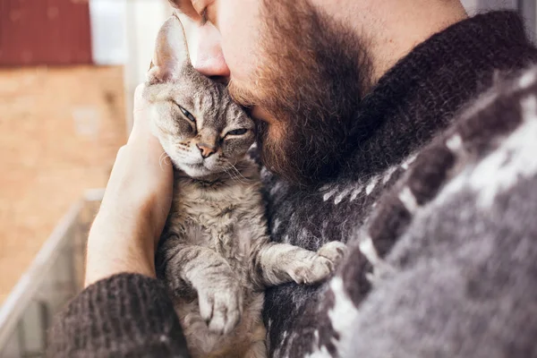 Close-up de jovem feliz que está de pé em uma varanda com seu gato . — Fotografia de Stock