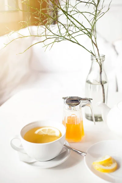 Xícara de chá verde quente com limão na mesa branca, limão fresco e mel close-up shot . — Fotografia de Stock
