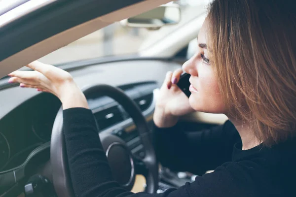 Hermosa mujer de negocios está hablando en el teléfono móvil mientras conduce el coche — Foto de Stock