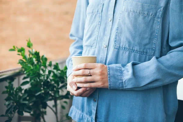 Mujer joven en azul casual jeans camisa está bebiendo café . — Foto de Stock
