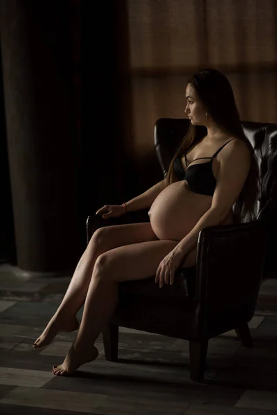 Kobiety Ciąży Sesja Zdjęciowa Ciemnym Klawiszu Usiądź Fotelu — Zdjęcie stockowe