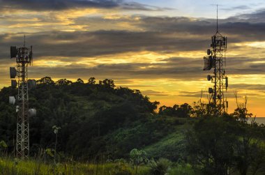 Telekomünikasyon ve radyo kuleleri ile Sao Paulo sahil devlet üzerinde arka planda günbatımı gökyüzü.