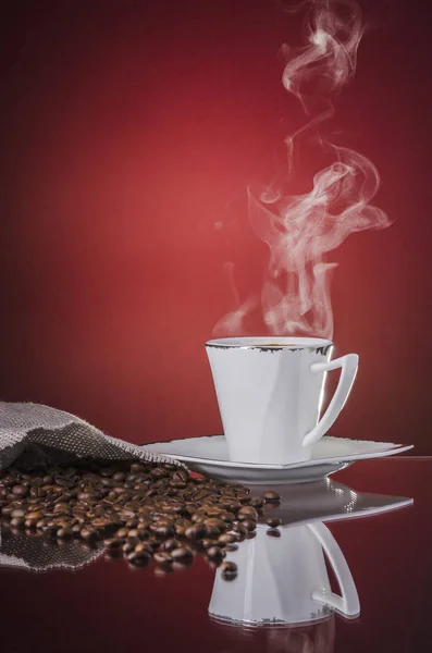 Eine Tasse heißen, dampfenden Kaffees auf rotem Hintergrund — Stockfoto