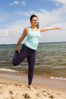 Yaz aylarında bir plajda fiziksel egzersizler pratik çekici genç kız