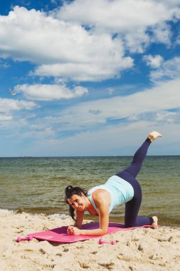 Yaz aylarında bir plajda fiziksel egzersizler pratik çekici genç kız