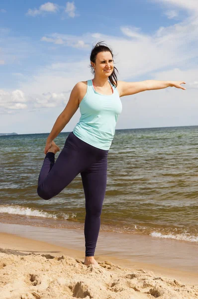 Yaz aylarında bir plajda fiziksel egzersizler pratik çekici genç kız