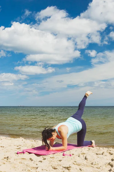 Yaz aylarında bir plajda fiziksel egzersizler pratik çekici genç kız