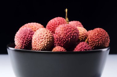 Lychee meyve koyu arka plan üzerinde izole bir kase