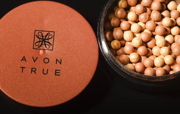 Kwidzyn, Polonya 1 Mart 2018: Avon parlayan koyu arka plan üzerinde izole bronzlama inciler. Avon ürünleri Inc David Mcconnell tarafından 1886 yılında İngiltere'de kurulmuştur. Avon güzellik, ev ve kişisel bakım kategorileri şirketinde satış doğrudan. 