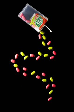 KWIDZYN, POLAND  MARCH 2, 2018: Falling tic tacs isolated on dark background. Tic tacs are manufactured by Italian confectioner Ferrero and were first produced in 1968. clipart