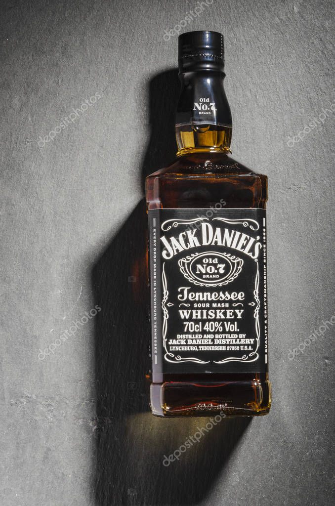 Bottle of Jack Daniels whiskey isolated on stone slate background. Jack Daniels sour mash whiskey has been distilled in Tennessee USA since 1866