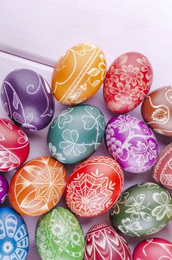 Ahşap masaya çizilmiş renkli el yapımı paskalya yumurtaları çeşitliliği