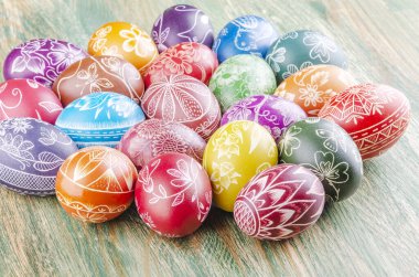 Ahşap masaya çizilmiş renkli el yapımı paskalya yumurtaları çeşitliliği
