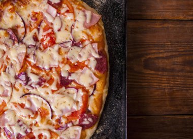 Kırsal ahşap masada ev yapımı pizza.