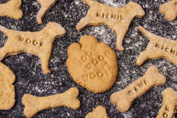 Biscotti per cani fatti in casa su sfondo nero Immagine Stock