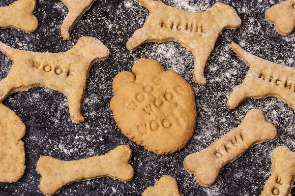 Galletas caseras de perro sobre fondo negro Imagen de archivo