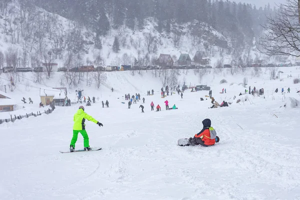 Maikop Adigeya Bölgesi, Rusya Federasyonu, 01.04.2019: Dağlarda kış tatili, farklı spor, aile eğlencesi, karlı ve bulutlu hava, yumuşak odak, metin için bir yer.
