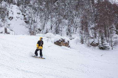  Maikop Adigeya Region,Russian Federation,01.04.2019 : Recreation in the mountains, active winter sports, snowboarding, leisure and enjoyment, emotions and feelings of self-satisfaction. clipart