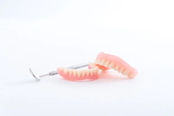 Set of denture and dental mirror, smile jaws teeth on white back — Stockfoto