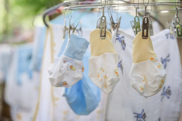 Baby laundry hanging on a clothesline with green nature backgrou — Stock Photo, Image