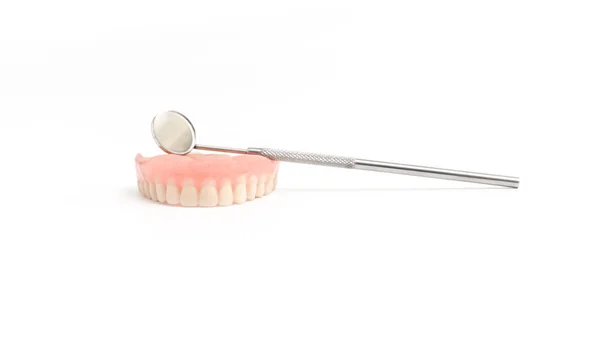 Upper dentures and dental mirror on white background — Stock Photo, Image