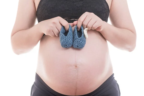Κλείστε τα μικρά παπούτσια για το αγέννητο μωρό στην κοιλιά της εγκύου — Φωτογραφία Αρχείου