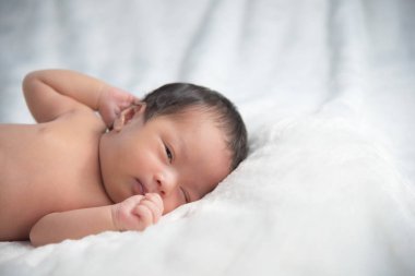 Şirin bebek çocuk beyaz battaniye ile yatakta yalan kadar kapatın