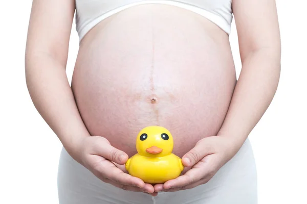 怀孕妇女肚子上戴着黄鸭玩具 — 图库照片
