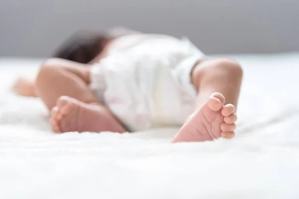 Nyfödd baby fötter på sängen — Stockfoto