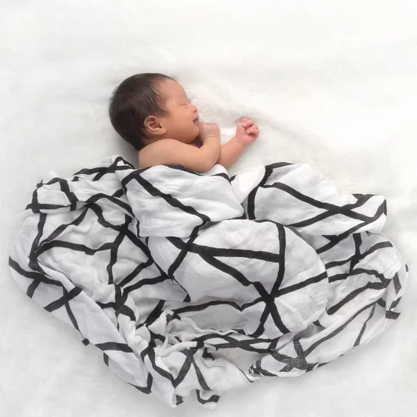 newborn baby sleeping sweetly on white blanket