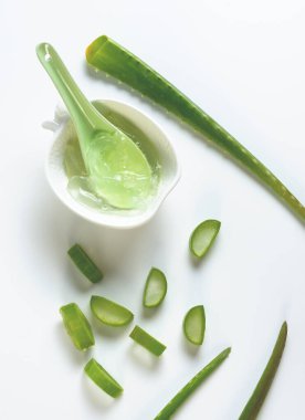 Aloe vera dilimlenmiş ve yeşil kaşıkla beyaz kasede.