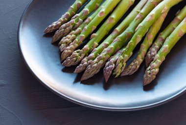 Kırsal siyah arka planda taze kuşkonmaz.