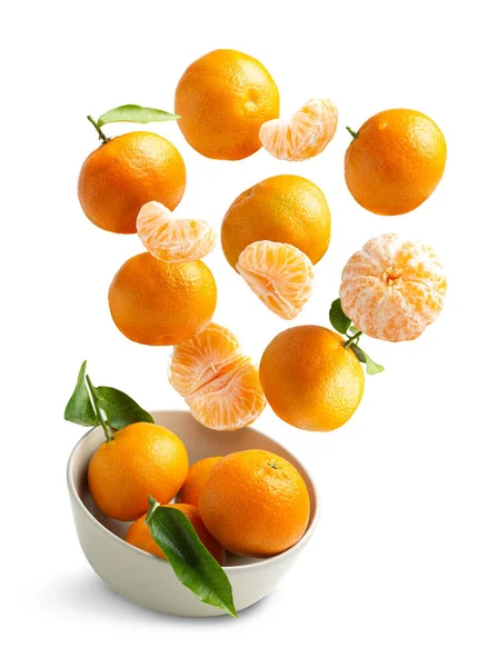 Beyaz arka planda uçan mandalinalar