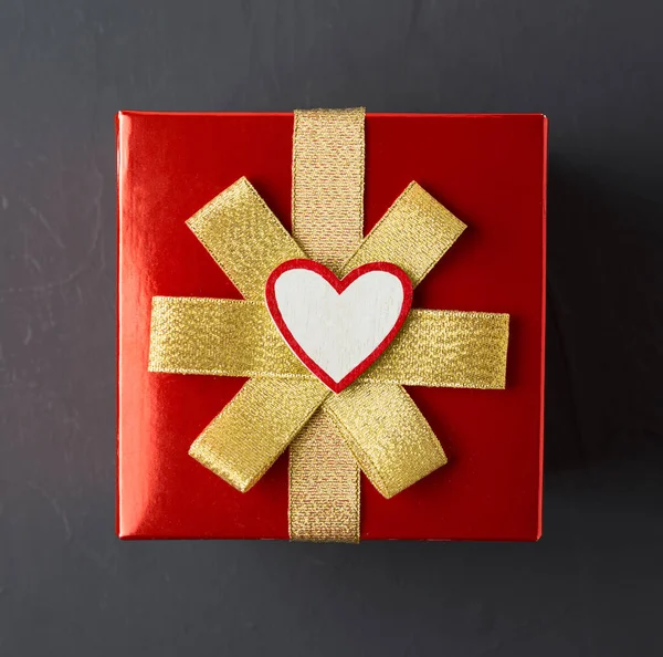 Regalo para el día de San Valentín, envuelto en papel de regalo rojo con oro —  Fotos de Stock