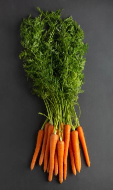 Siyah köy arka planında bir sürü taze havuç.