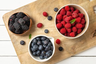 three bowls with wild berries, raspberry, blueberries, blackberries, zenith view
