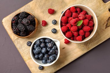 three bowls with wild berries, raspberry, blueberries, blackberries, zenith view