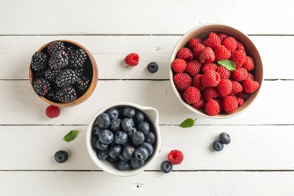 Three bowls with wild berries, raspberry, blueberries, blackberries, zenith view — ストック写真