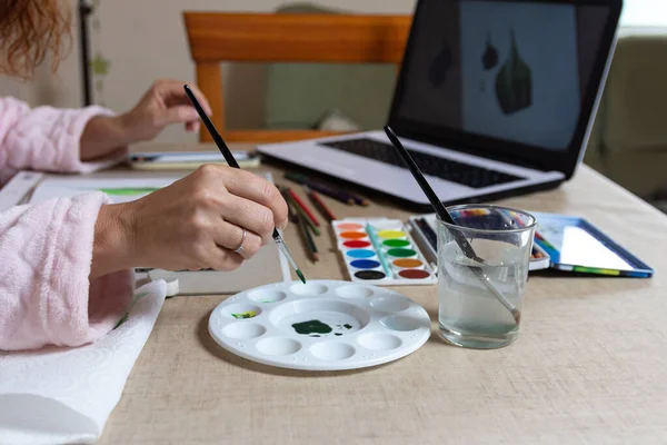 İnternette suluboya resim kursu alan bir kadın. Coranavirus 'un hapsedilmesine karşı eğlence.