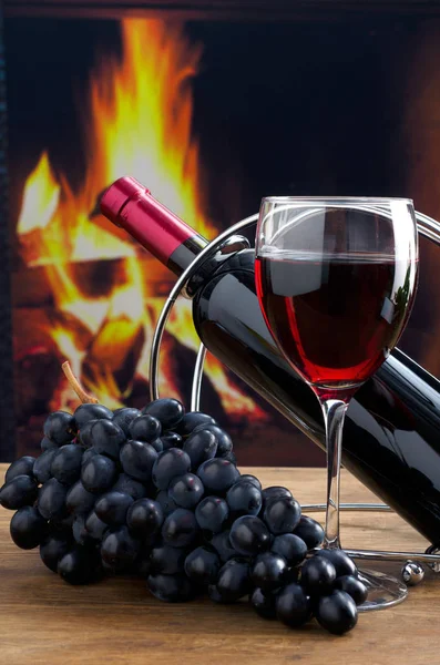 Бутылка вина и бокал вина на фоне огня — стоковое фото