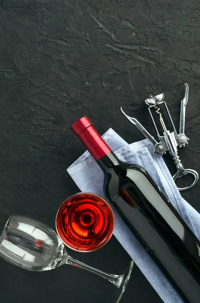 Bottle, wine glasses with wine and corkscrew on dark background — Stock Photo, Image