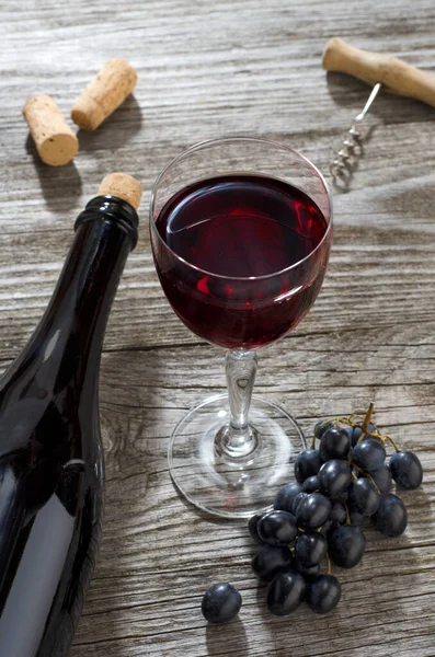 Bicchiere Vino Rosso Bottiglia Vino Grappolo Uva Blu Cavatappi Tavolo — Foto Stock