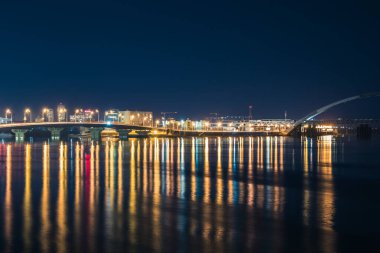 Gece Kiev 'deki Havana Köprüsü Dnipro nehrinde renkli aydınlatma ve yansıma ile