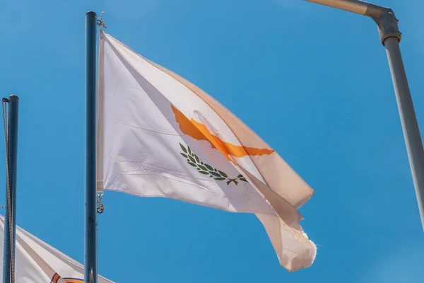 Kıbrıs ulusal bayrağı. Bayrak direğinde ışık var. Yaz rüzgarı dalgalanır bayrak.