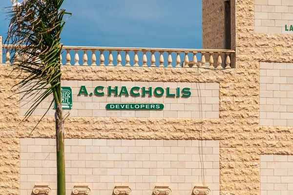 Agia Napa, Kıbrıs - 26 Mayıs 2019: Nissi Beach Resort Hotel tabelası, Ayia Napa. Bu işaret palmiye ağaçlarının arka planında çalılıklara asılmış..