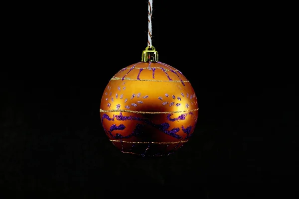 白い背景で撮影した紫と金色の装飾品でオレンジ色のクリスマス ボール — ストック写真